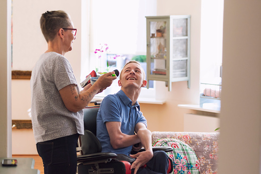 Support worker engaging warmly with NDIS participant at home